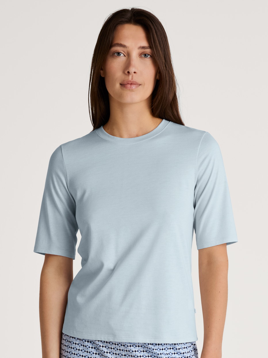 Damen-Model trägt Kurzarm-Shirt aus Modal in Blau, Einfarbig aus Serie Favourites Joy von CALIDA, Vorderansicht