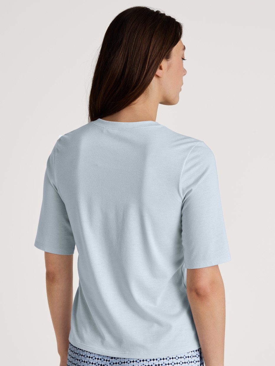 Damen-Model trägt Kurzarm-Shirt aus Modal in Blau, Einfarbig aus Serie Favourites Joy von CALIDA, Rückansicht