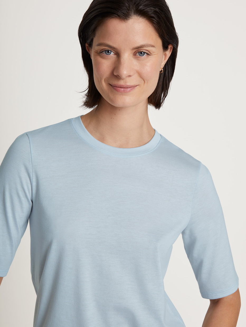 Damen-Model trägt Kurzarm-Shirt aus Modal in Blau, Einfarbig aus Serie Favourites Joy von CALIDA, Detail