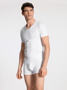 La modella / Il modello Uomo indossa T-shirt con scollo a V, set da 2 in Cotone di colore Bianco, Tinta unita, della serie Natural Benefit di CALIDA, Vista frontale, Abbigliamento