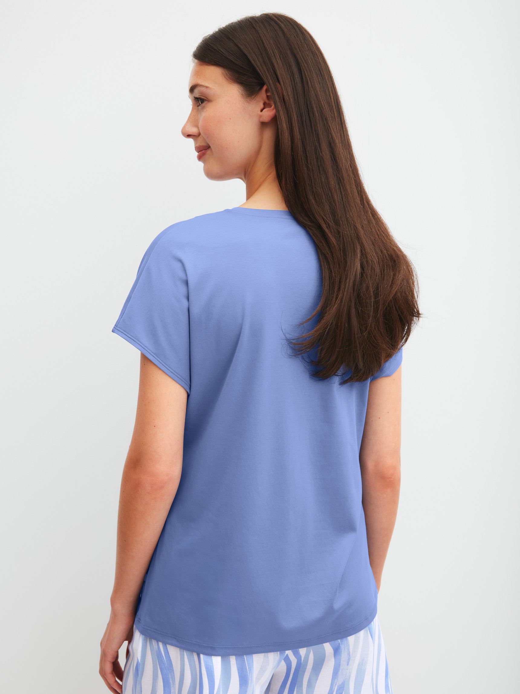 Women model is wearing Short-sleeved shirt with V-neck made of Cotton in Blue, Unicoloured from the Favourites Ocean series by CALIDA, Back view
