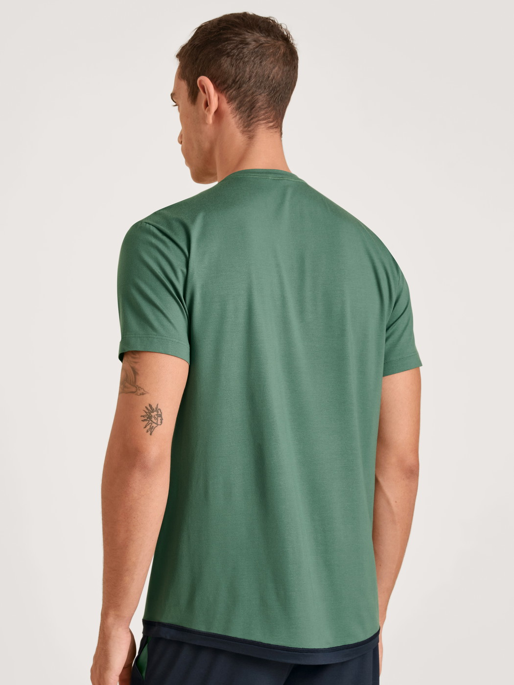 Herren-Model trägt Kurzarm-Shirt aus Modal in Grün, Einfarbig aus Serie DSW Balancing von CALIDA, Rückansicht