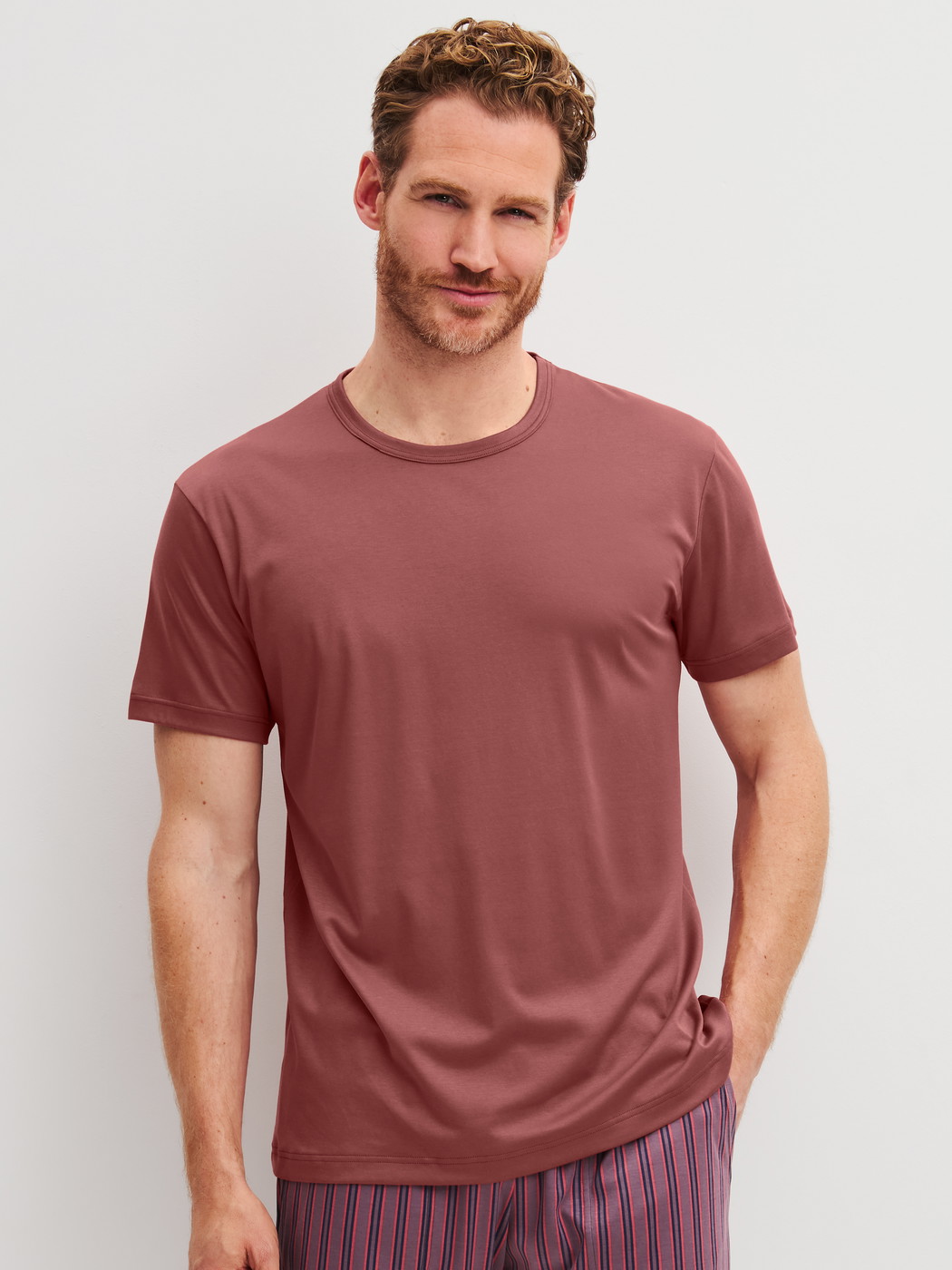Herren-Model trägt Kurzarm-Shirt aus Baumwolle in Orange, Einfarbig aus Serie RMX Sleep Superlight von CALIDA, Vorderansicht