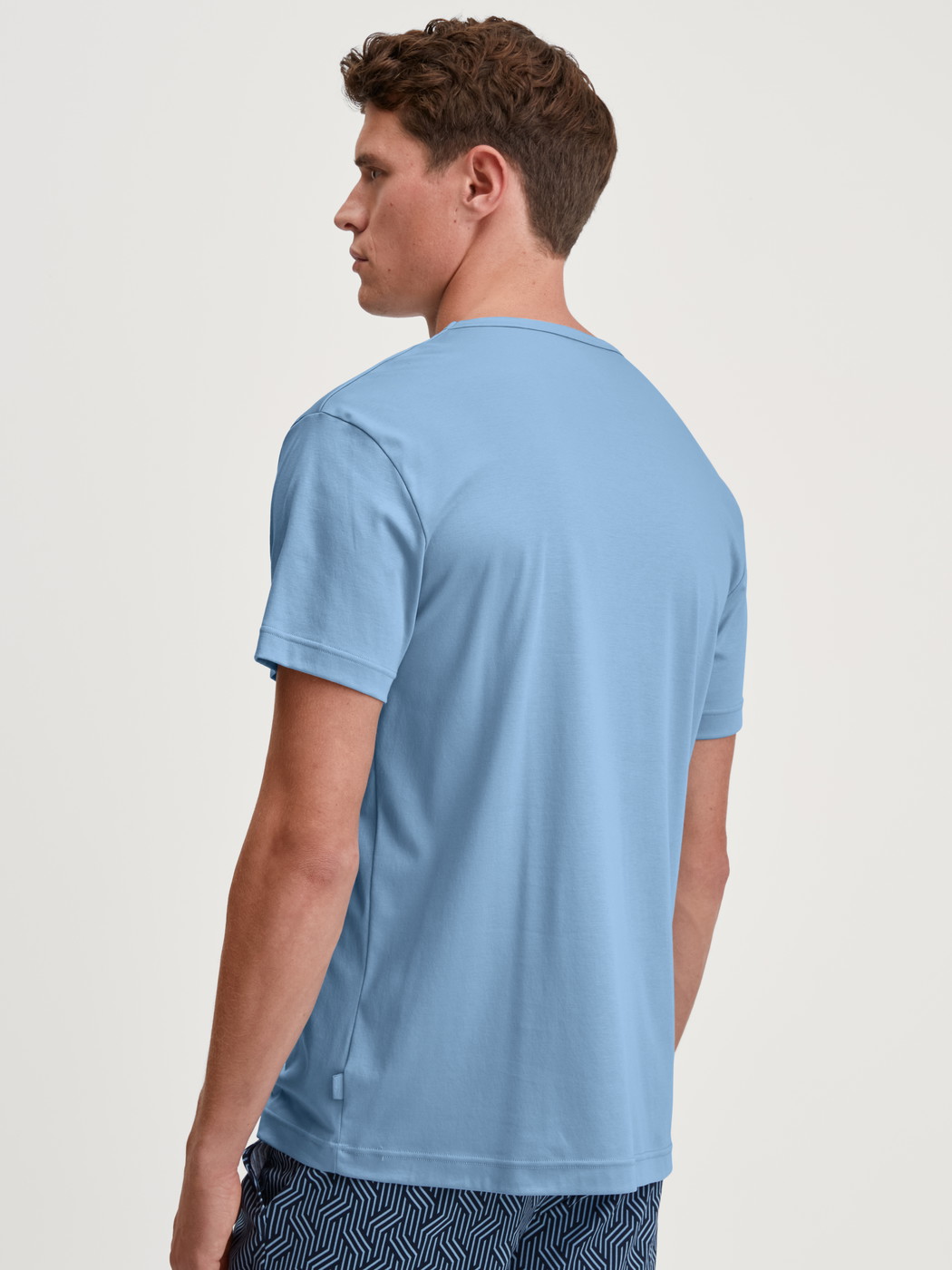 La modella / Il modello Uomo indossa Maglietta a maniche corte in Cotone di colore Blu, Tinta unita, della serie RMX Sleep Free di CALIDA, Vista posteriore