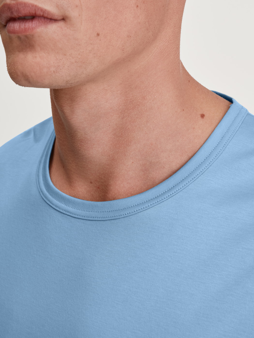 La modella / Il modello Uomo indossa Maglietta a maniche corte in Cotone di colore Blu, Tinta unita, della serie RMX Sleep Free di CALIDA, Dettaglio