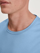 La modella / Il modello Uomo indossa Maglietta a maniche corte in Cotone di colore Blu, Tinta unita, della serie RMX Sleep Free di CALIDA, Dettaglio