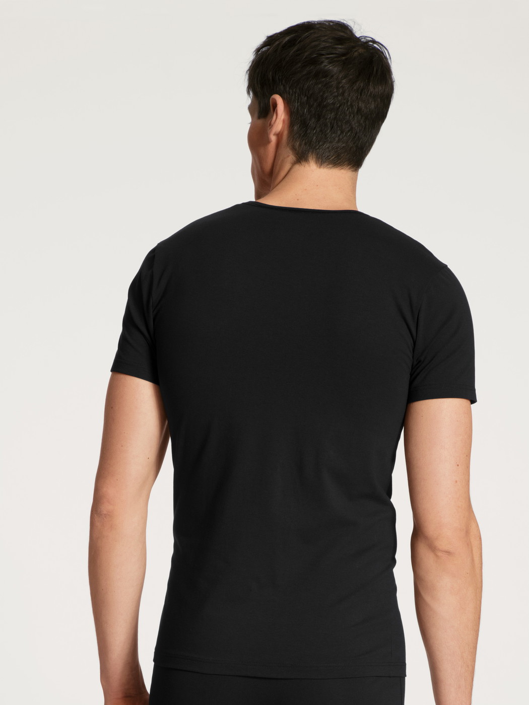La modella / Il modello Uomo indossa T-Shirt in Cotone di colore Nero, Tinta unita, della serie Cotton Code di CALIDA, Vista posteriore