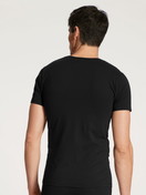 La modella / Il modello Uomo indossa T-Shirt in Cotone di colore Nero, Tinta unita, della serie Cotton Code di CALIDA, Vista posteriore