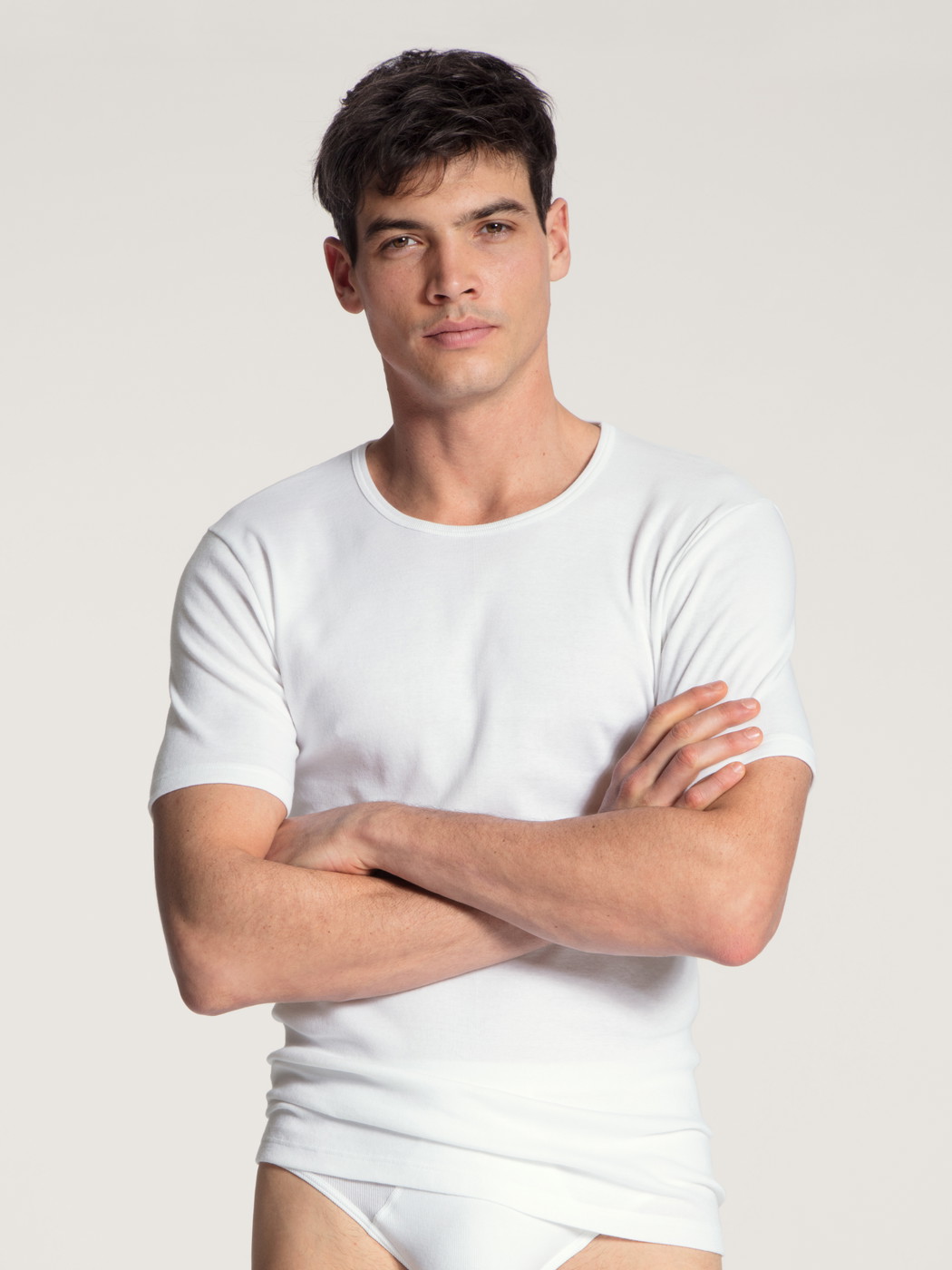 La modella / Il modello Uomo indossa T-shirt in 100% cotone di colore Bianco, Tinta unita, della serie Cotton 1:1 di CALIDA, Vista frontale