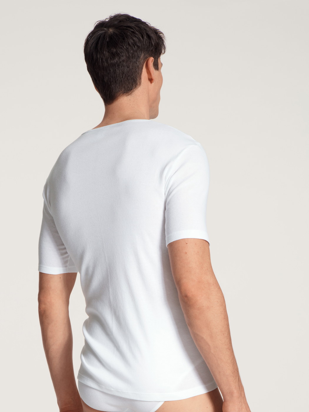 La modella / Il modello Uomo indossa T-shirt in 100% cotone di colore Bianco, Tinta unita, della serie Cotton 1:1 di CALIDA, Vista posteriore
