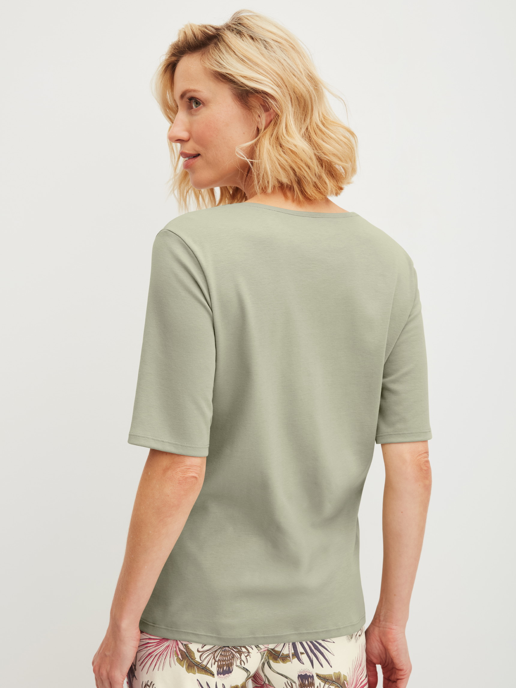 Damen-Model trägt Kurzarm-Shirt aus 100% Baumwolle in Grün, Einfarbig aus Serie Favourites Arts von CALIDA, Rückansicht
