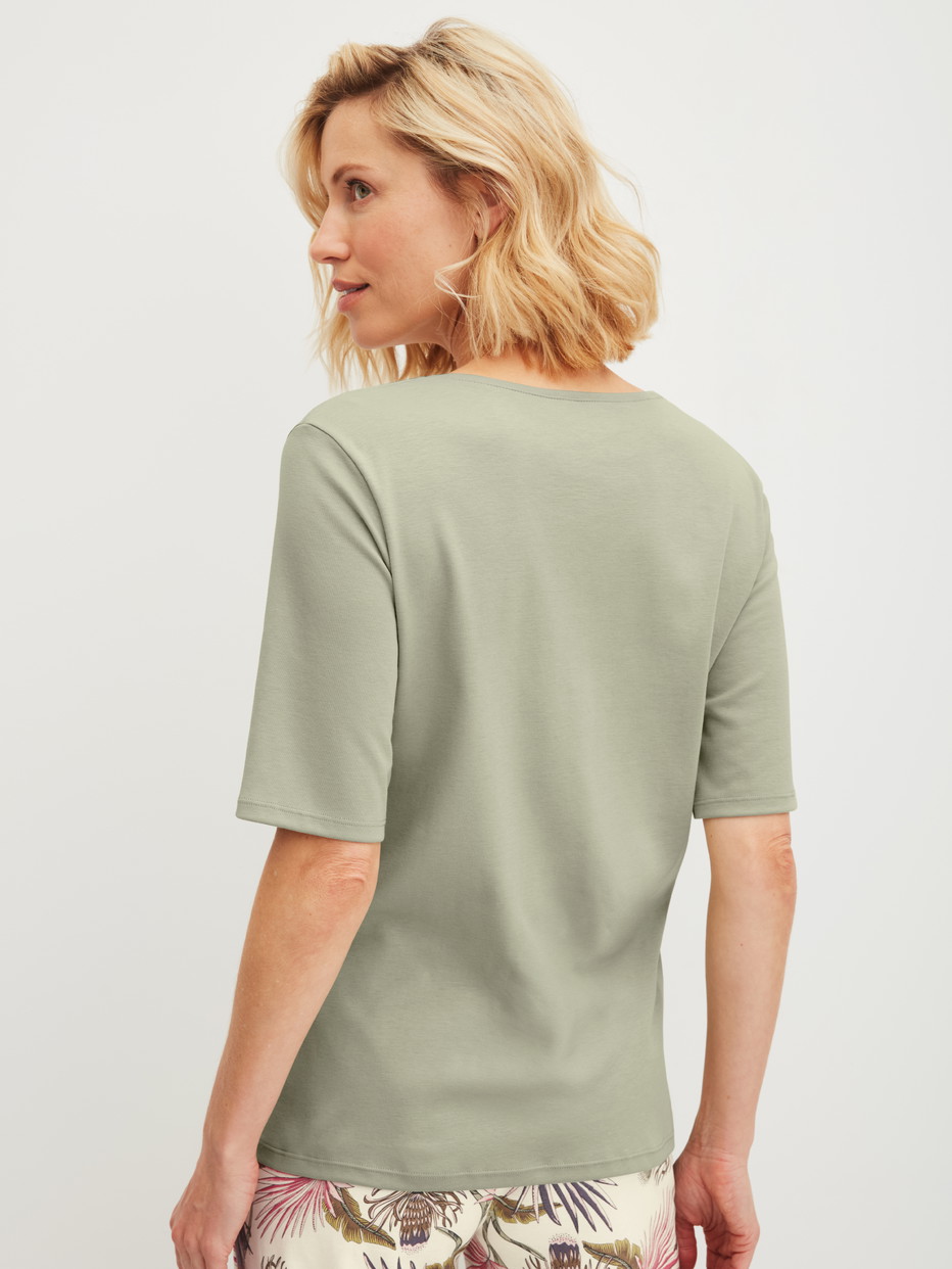 Damen-Model trägt Kurzarm-Shirt aus 100% Baumwolle in Grün, Einfarbig aus Serie Favourites Arts von CALIDA, Rückansicht