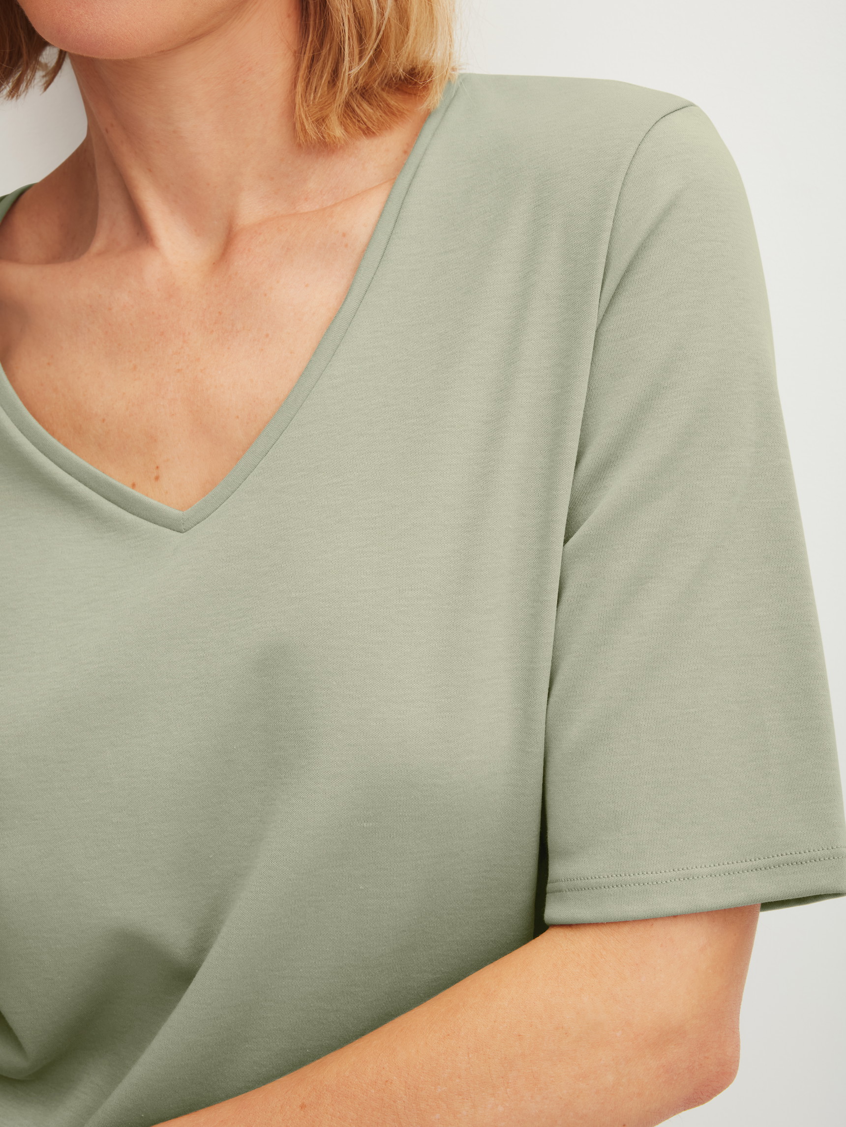 Damen-Model trägt Kurzarm-Shirt aus 100% Baumwolle in Grün, Einfarbig aus Serie Favourites Arts von CALIDA, Detail