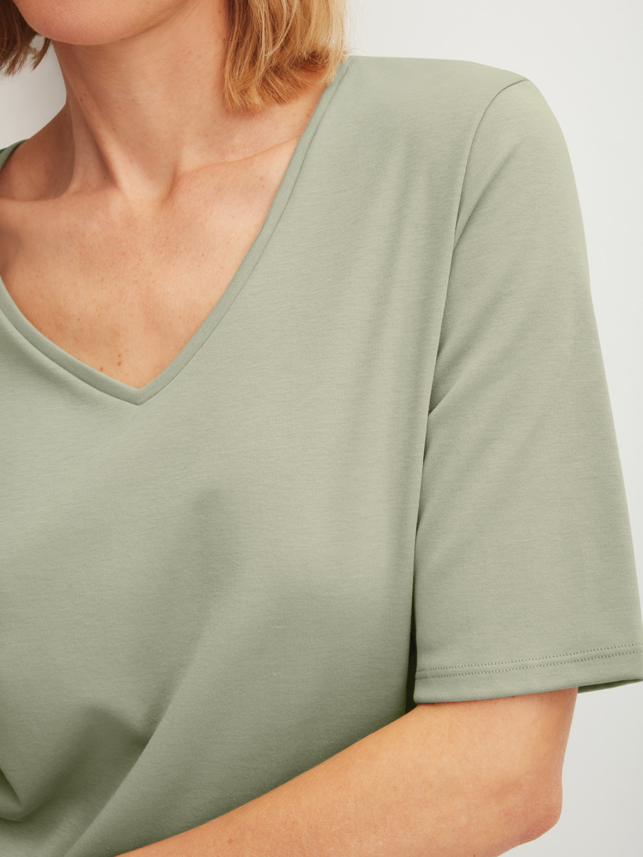 Damen-Model trägt Kurzarm-Shirt aus 100% Baumwolle in Grün, Einfarbig aus Serie Favourites Arts von CALIDA, Detail