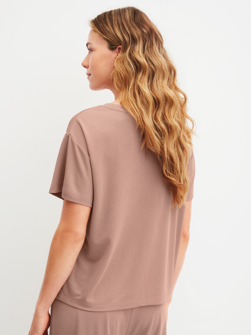 Damen-Model trägt Kurzarm-Shirt aus Modal in Braun, Einfarbig aus Serie Natural Loungewear von CALIDA, Rückansicht