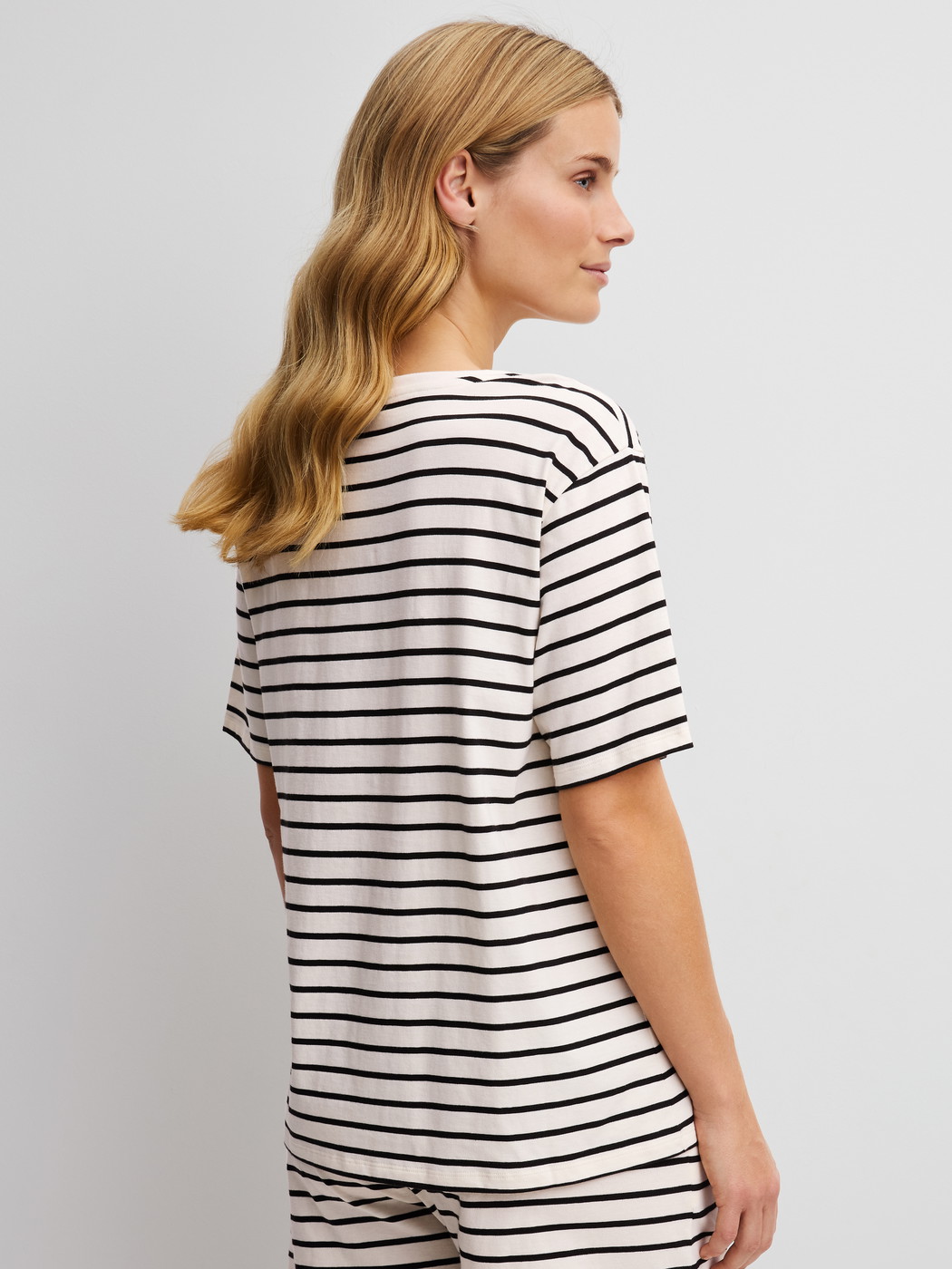Damen-Model trägt Kurzarm-Shirt aus Viskose in Schwarz, Gestreift aus Serie Favourites Layering von CALIDA, Rückansicht