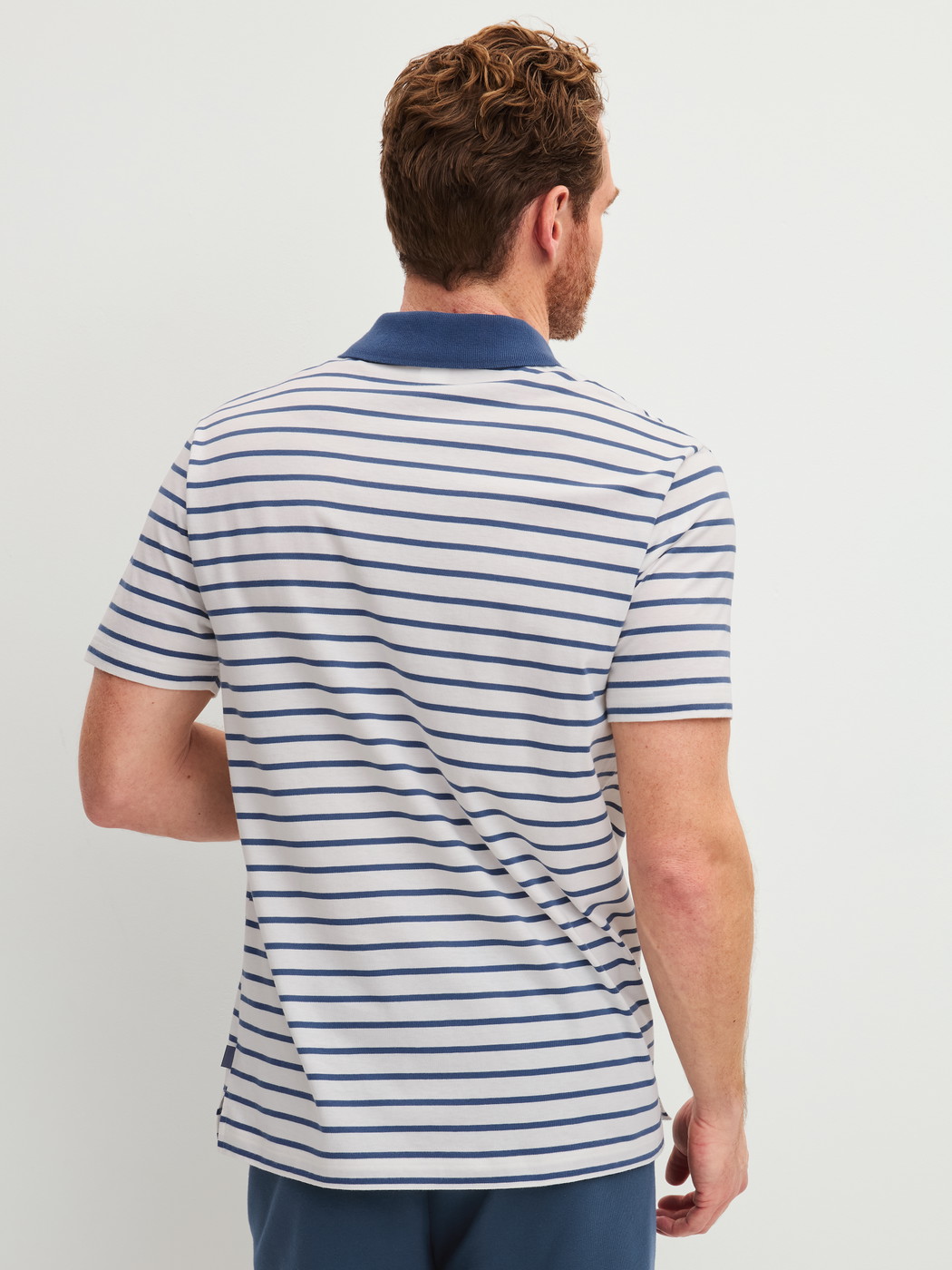 Herren-Model trägt Polo-Shirt aus 100% Baumwolle in Blau, Gestreift aus Serie RMX Lounge Journey von CALIDA, Rückansicht