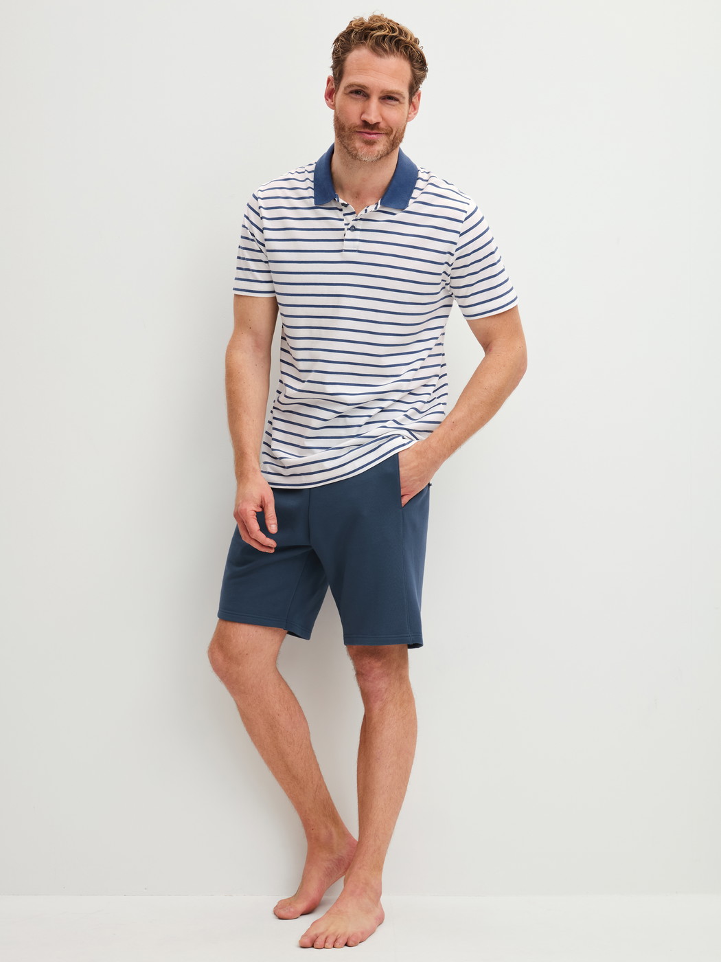 Herren-Model trägt Polo-Shirt aus 100% Baumwolle in Blau, Gestreift aus Serie RMX Lounge Journey von CALIDA, Outfit