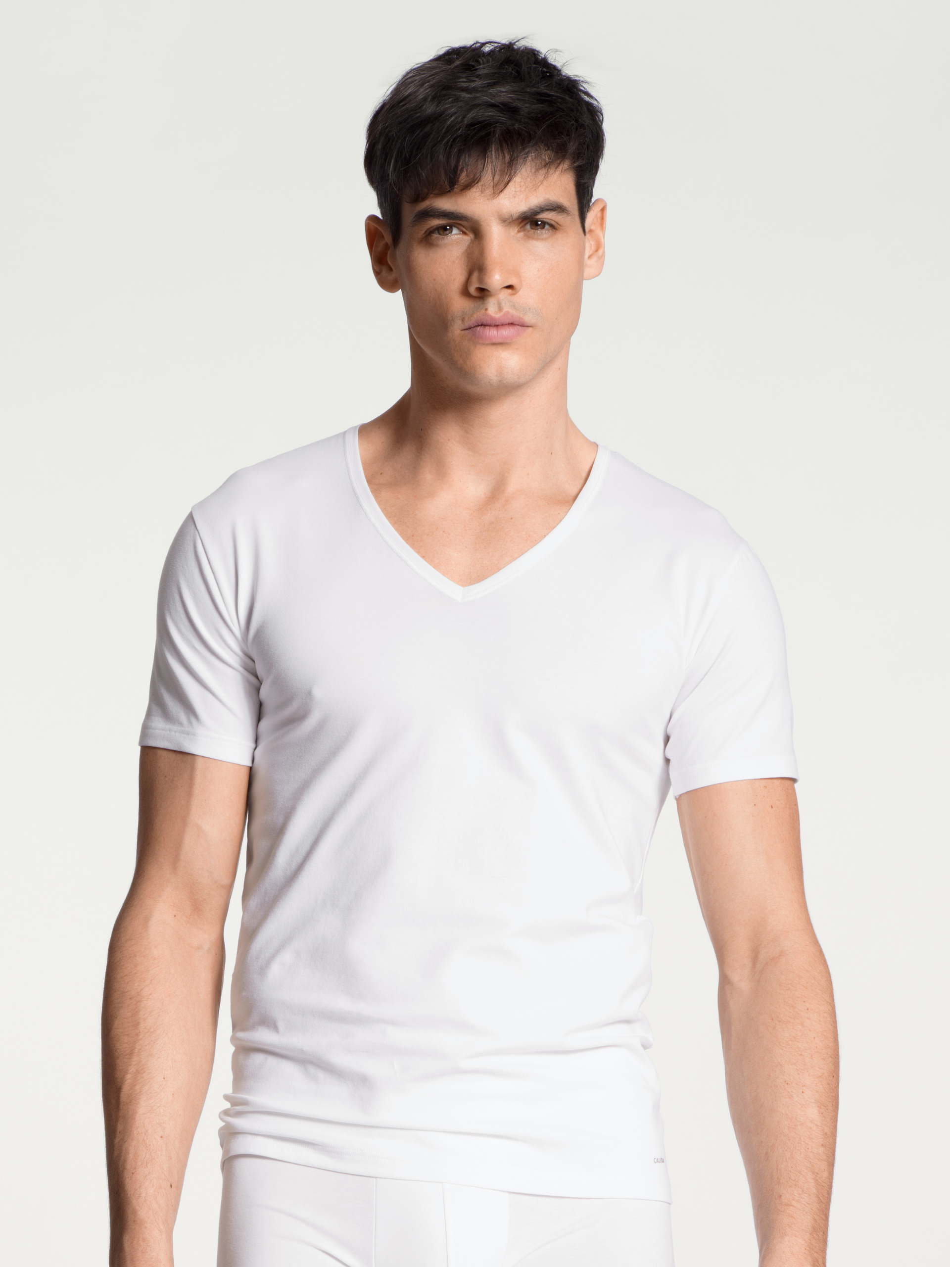 Herren-Model trägt T-Shirt, V-Neck aus Baumwolle in Weiß, Einfarbig aus Serie Cotton Code von CALIDA, Vorderansicht