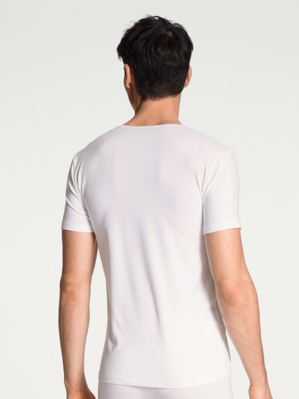 La modella / Il modello Uomo indossa V-Shirt in Cotone di colore Bianco, Tinta unita, della serie Cotton Code di CALIDA, Vista posteriore