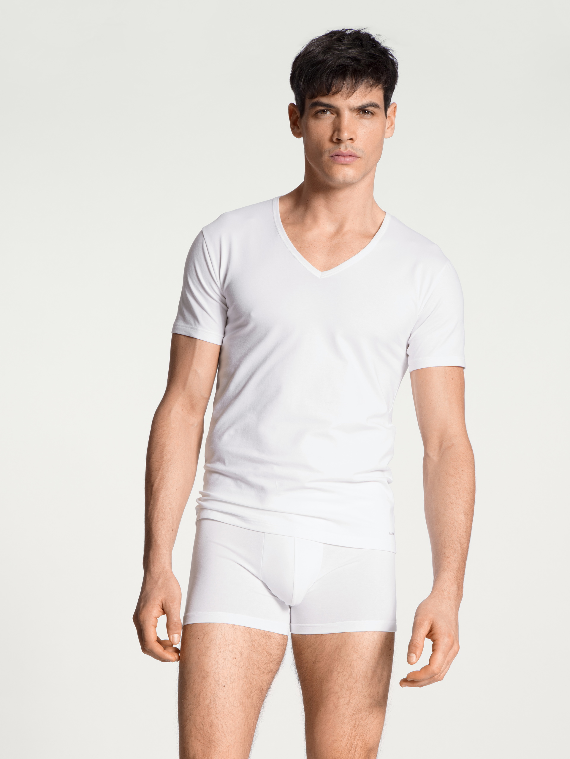 Herren-Model trägt T-Shirt, V-Neck aus Baumwolle in Weiß, Einfarbig aus Serie Cotton Code von CALIDA, Outfit, Vorderansicht