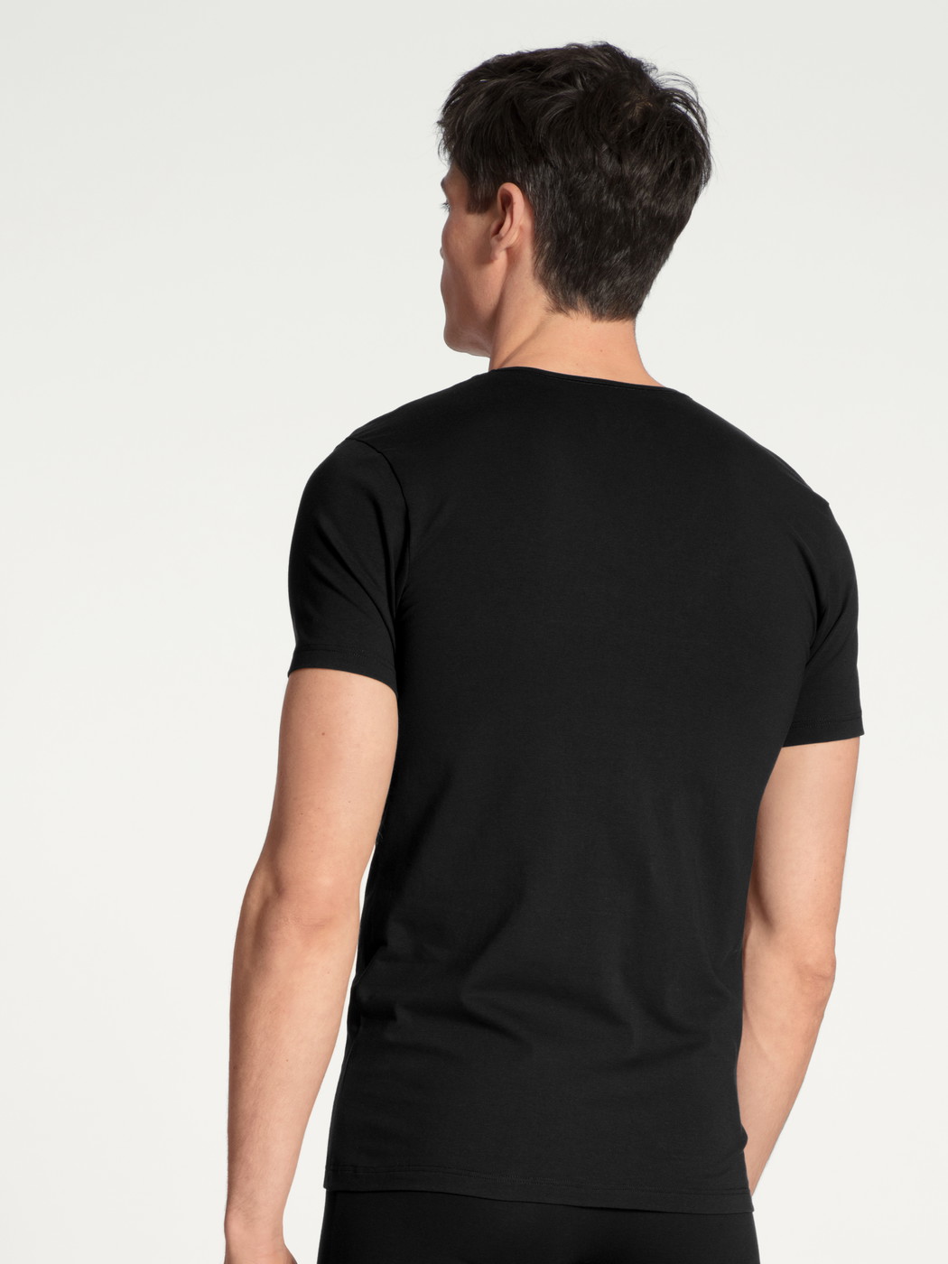 La modella / Il modello Uomo indossa V-Shirt in Cotone di colore Nero, Tinta unita, della serie Cotton Code di CALIDA, Vista posteriore