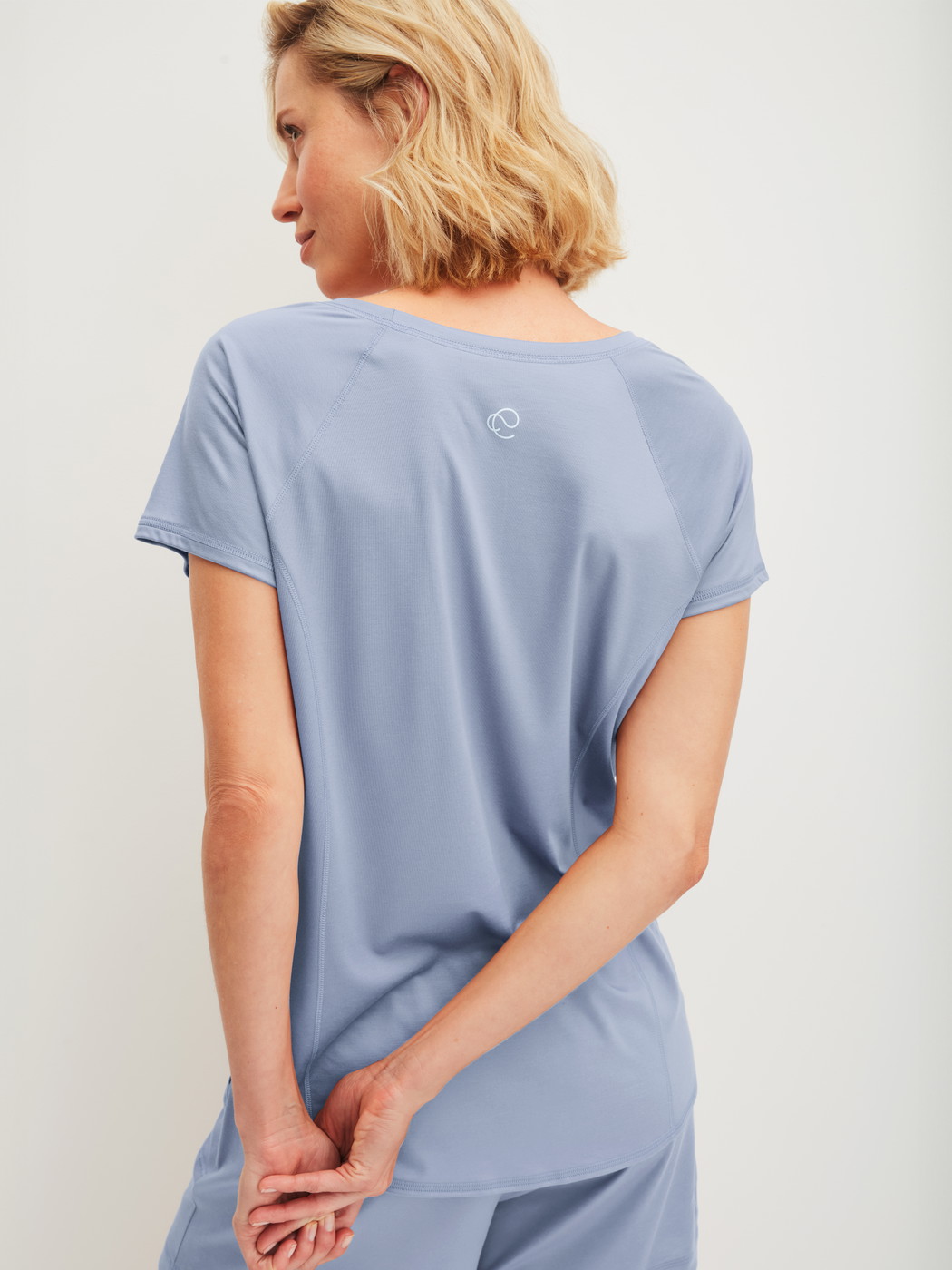 Women model is wearing Shirt short sleeve made of Lyocell in Blue, Unicoloured from the DSW Cooling series by CALIDA, Back view