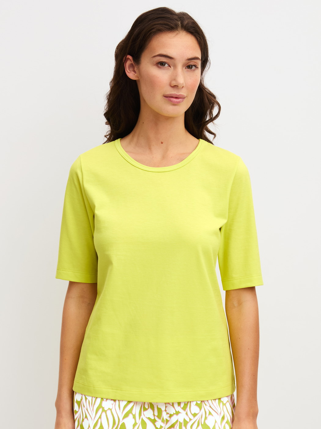 Damen-Model trägt Kurzarm-Shirt aus 100% Baumwolle in Grün, Einfarbig aus Serie Late Bloom M&M von CALIDA, Vorderansicht