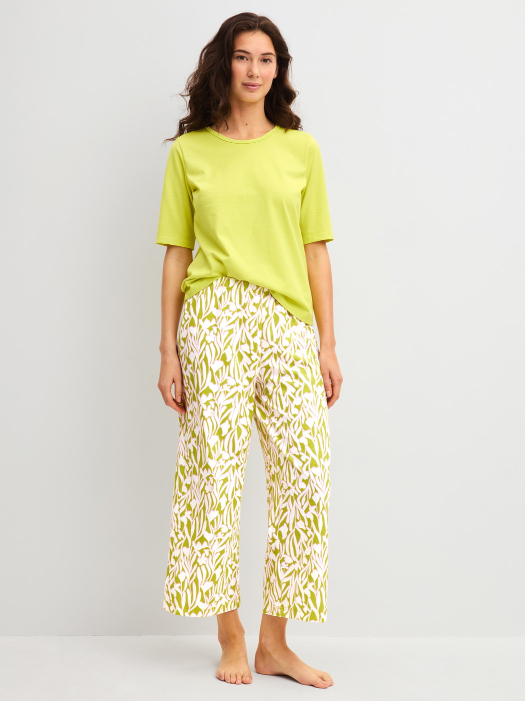 Damen-Model trägt Kurzarm-Shirt aus 100% Baumwolle in Grün, Einfarbig aus Serie Late Bloom M&M von CALIDA, Outfit