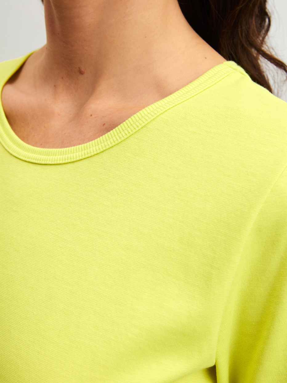 Damen-Model trägt Kurzarm-Shirt aus 100% Baumwolle in Grün, Einfarbig aus Serie Late Bloom M&M von CALIDA, Detail