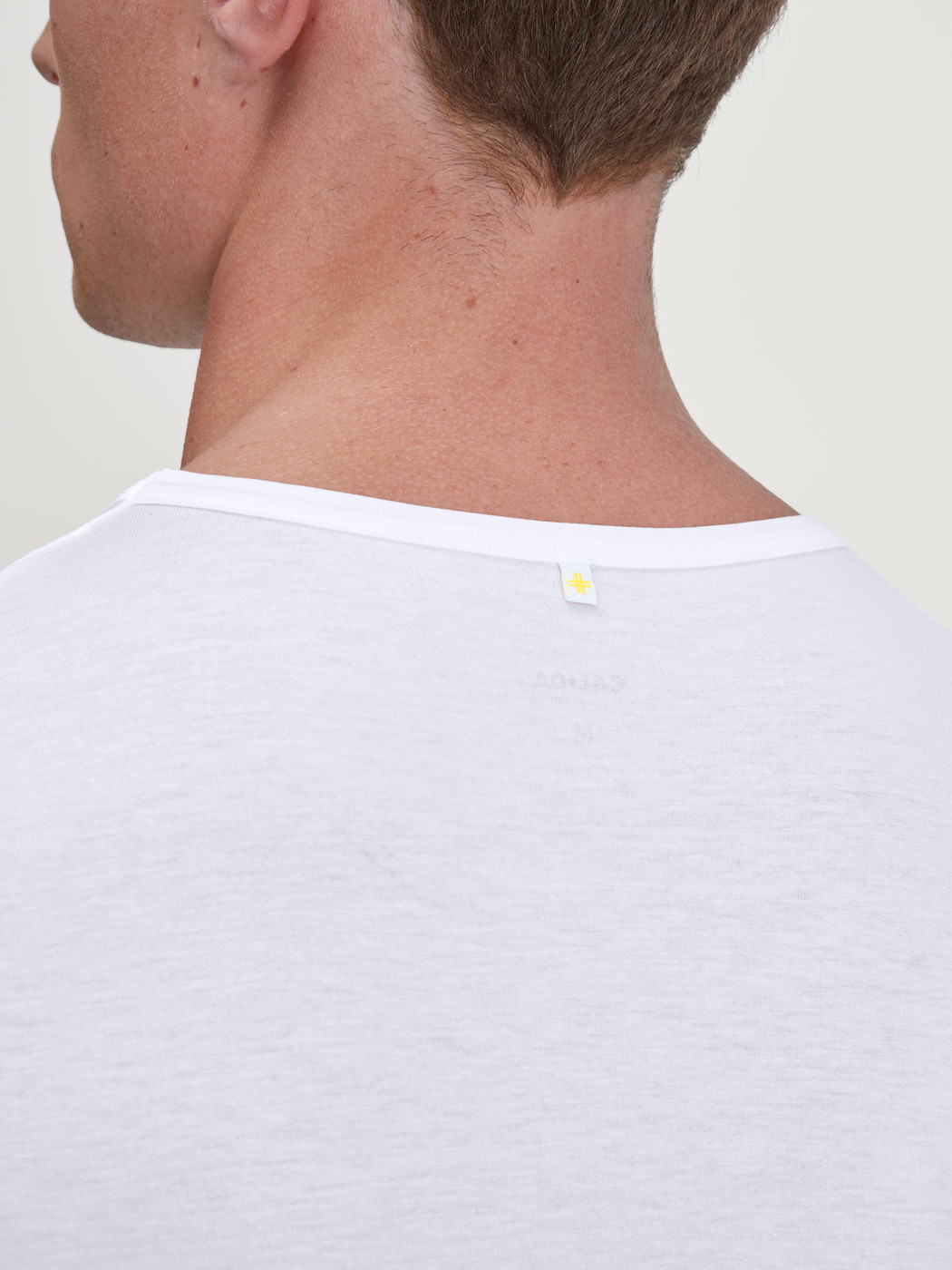 Herren-Model trägt T-Shirt aus TENCEL™ in Weiß, Einfarbig aus Serie Natural Cooling von CALIDA, Detail