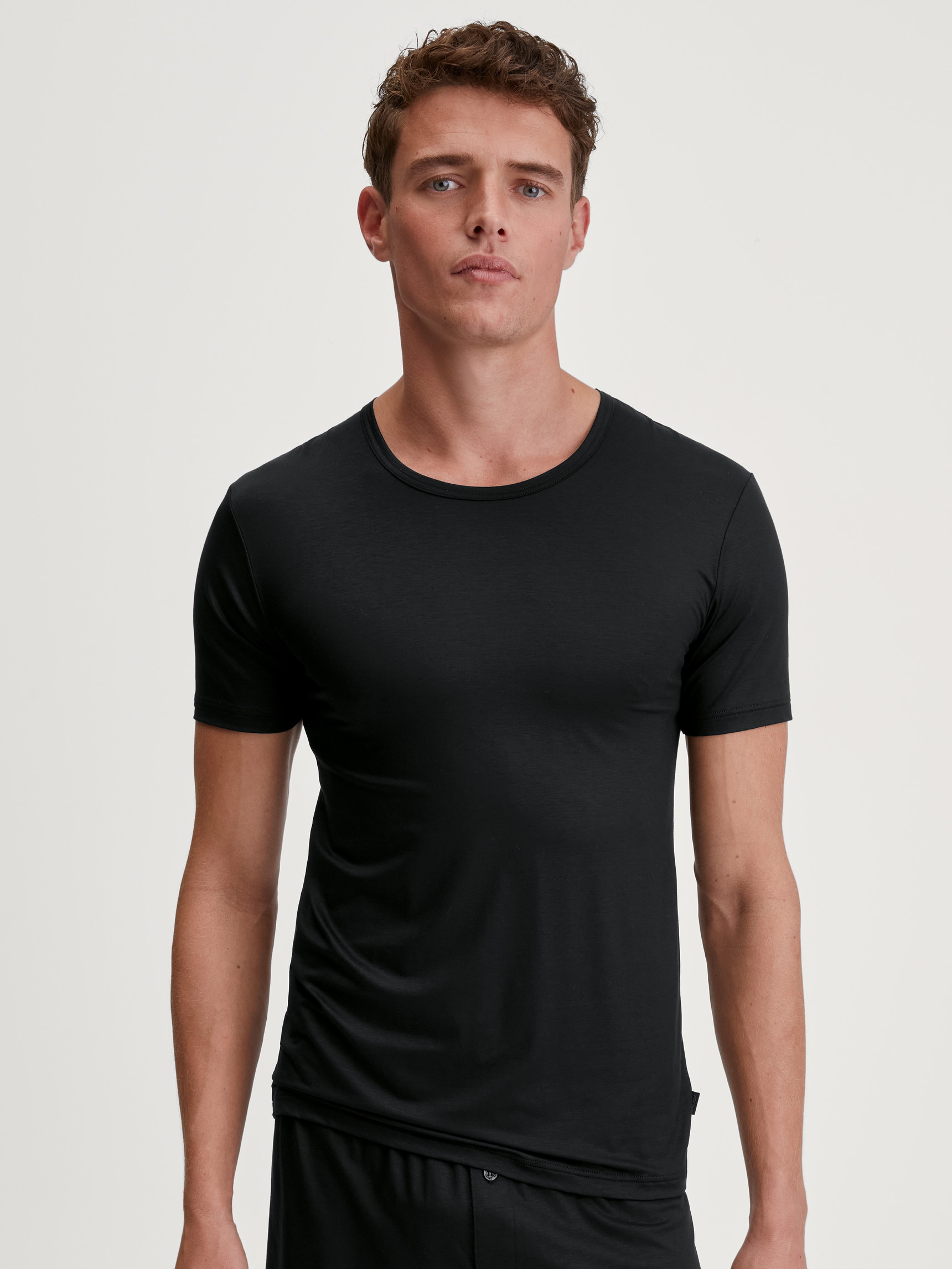 Herren-Model trägt T-Shirt aus TENCEL™ in Schwarz, Einfarbig aus Serie Natural Cooling von CALIDA, Vorderansicht