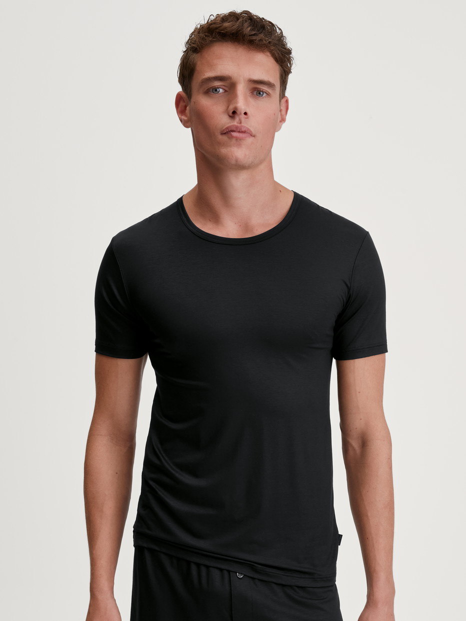 Herren-Model trägt T-Shirt aus TENCEL™ in Schwarz, Einfarbig aus Serie Natural Cooling von CALIDA, Vorderansicht