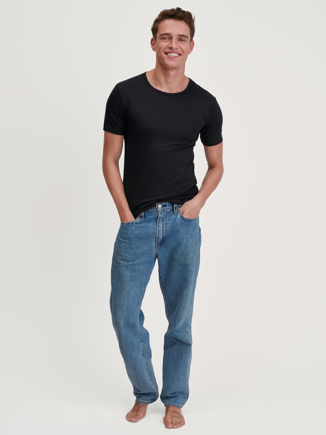 Herren-Model trägt T-Shirt aus TENCEL™ in Schwarz, Einfarbig aus Serie Natural Cooling von CALIDA, Outfit