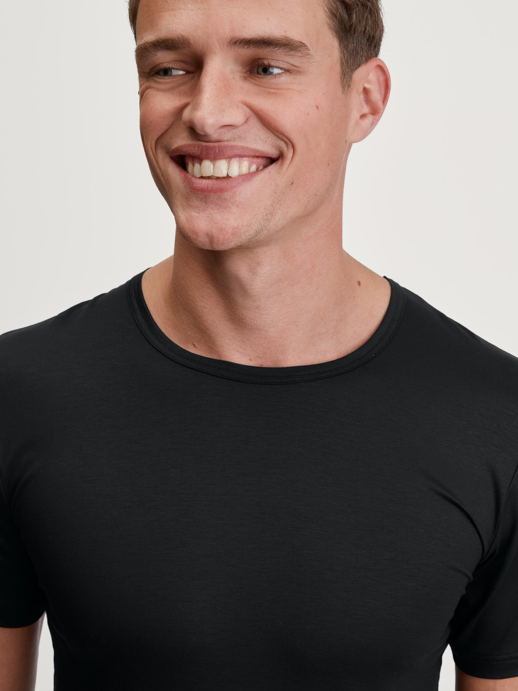 Herren-Model trägt T-Shirt aus TENCEL™ in Schwarz, Einfarbig aus Serie Natural Cooling von CALIDA, Detail