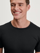 Herren-Model trägt T-Shirt aus TENCEL™ in Schwarz, Einfarbig aus Serie Natural Cooling von CALIDA, Detail