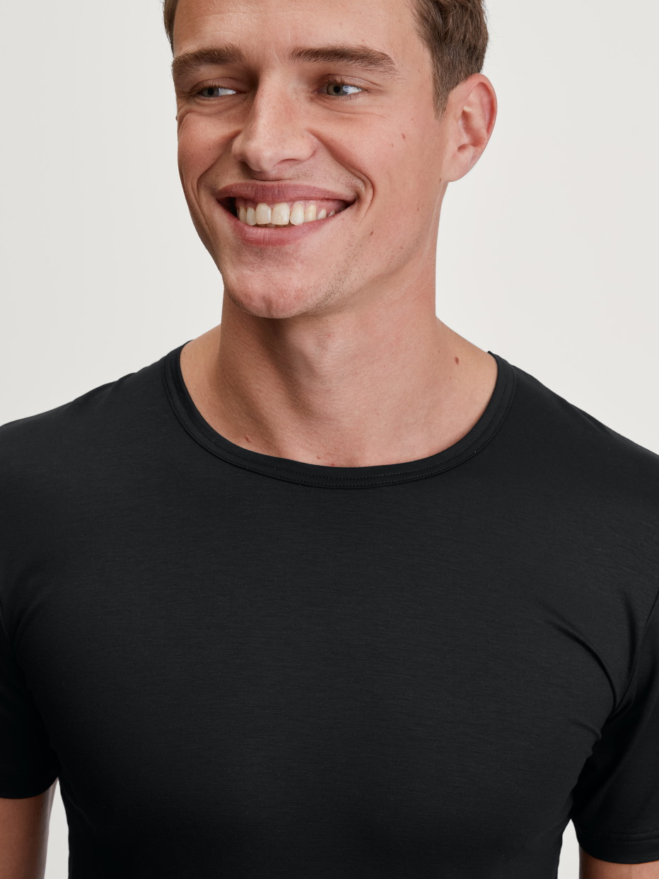 Herren-Model trägt T-Shirt aus TENCEL™ in Schwarz, Einfarbig aus Serie Natural Cooling von CALIDA, Detail
