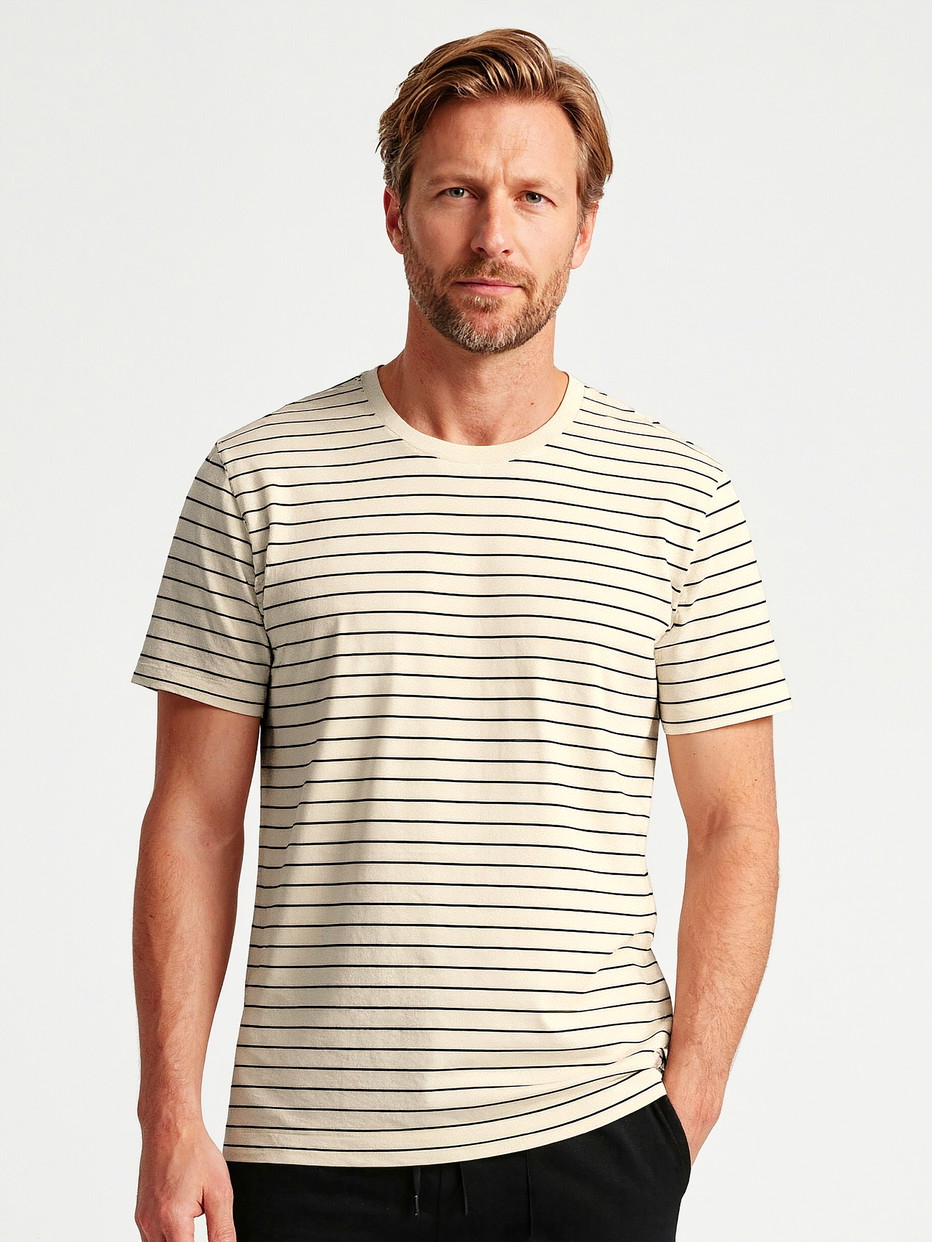 Herren-Model trägt Kurzarm-Shirt aus Viskose in Schwarz, Gestreift aus Serie RMX Lounge Lecce von CALIDA, Vorderansicht, KI-generiertes Bild
