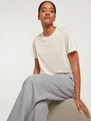 Damen-Model trägt Kurzarm-Shirt aus Modal in Weiß, Einfarbig aus Serie Lounge & Relax von CALIDA