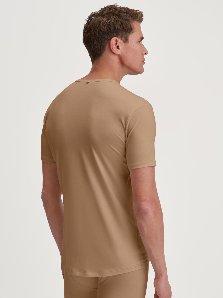Herren-Model trägt Business-Unterhemd mit Achselpads aus TENCEL™ in Beige, Einfarbig aus Serie Natural Cooling von CALIDA, Rückansicht