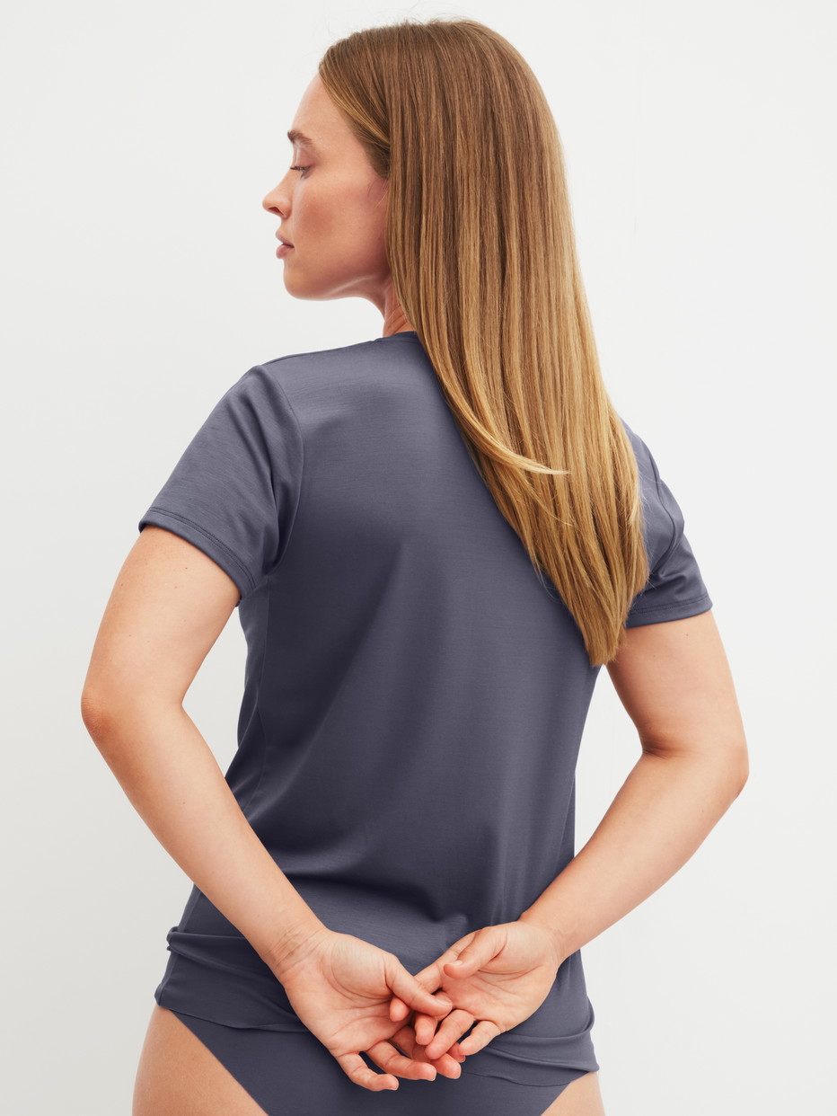 Damen-Model trägt Kurzarm-Shirt aus Modal in Grau, Einfarbig aus Serie Natural Skin von CALIDA, Rückansicht