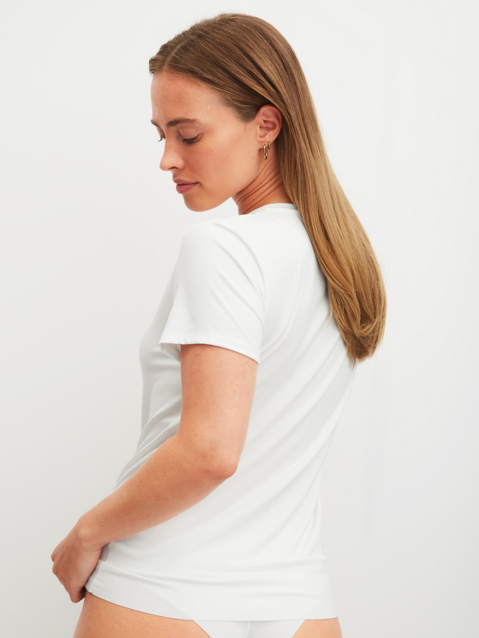 La modella / Il modello Donna indossa Shirt a manica corta in Modal di colore Bianco, Tinta unita, della serie Natural Skin di CALIDA, Vista posteriore