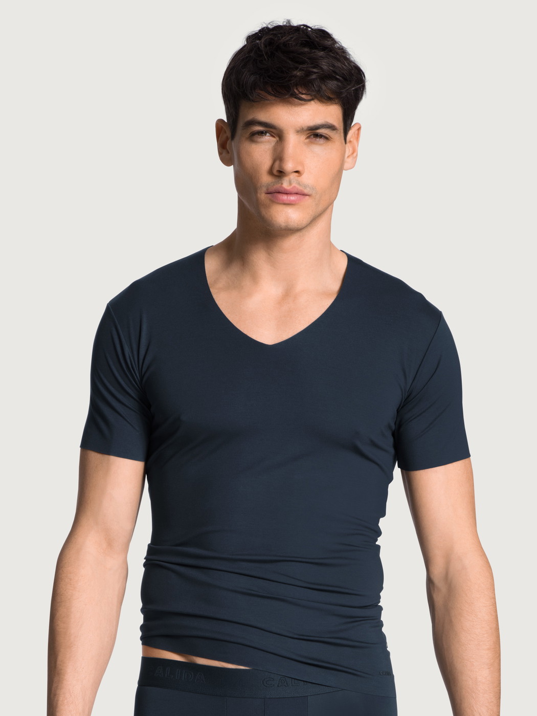 Herren-Model trägt Kurzarm-Shirt, V-Neck aus Modal in Blau, Einfarbig aus Serie Clean Line von CALIDA, Vorderansicht