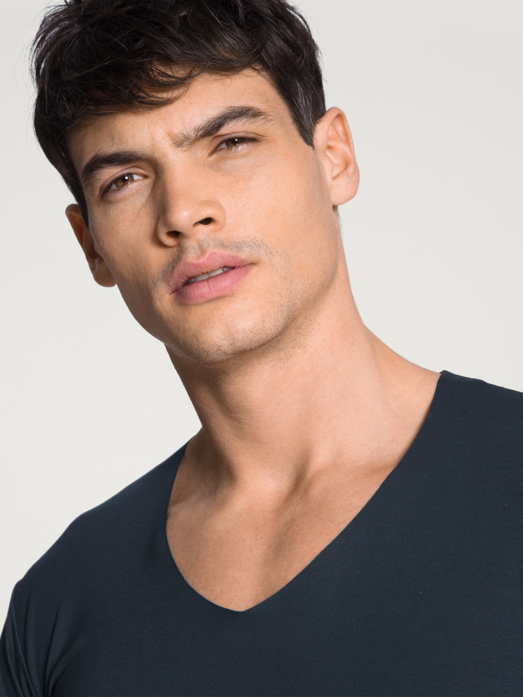 Herren-Model trägt Kurzarm-Shirt, V-Neck aus Modal in Blau, Einfarbig aus Serie Clean Line von CALIDA, Detail