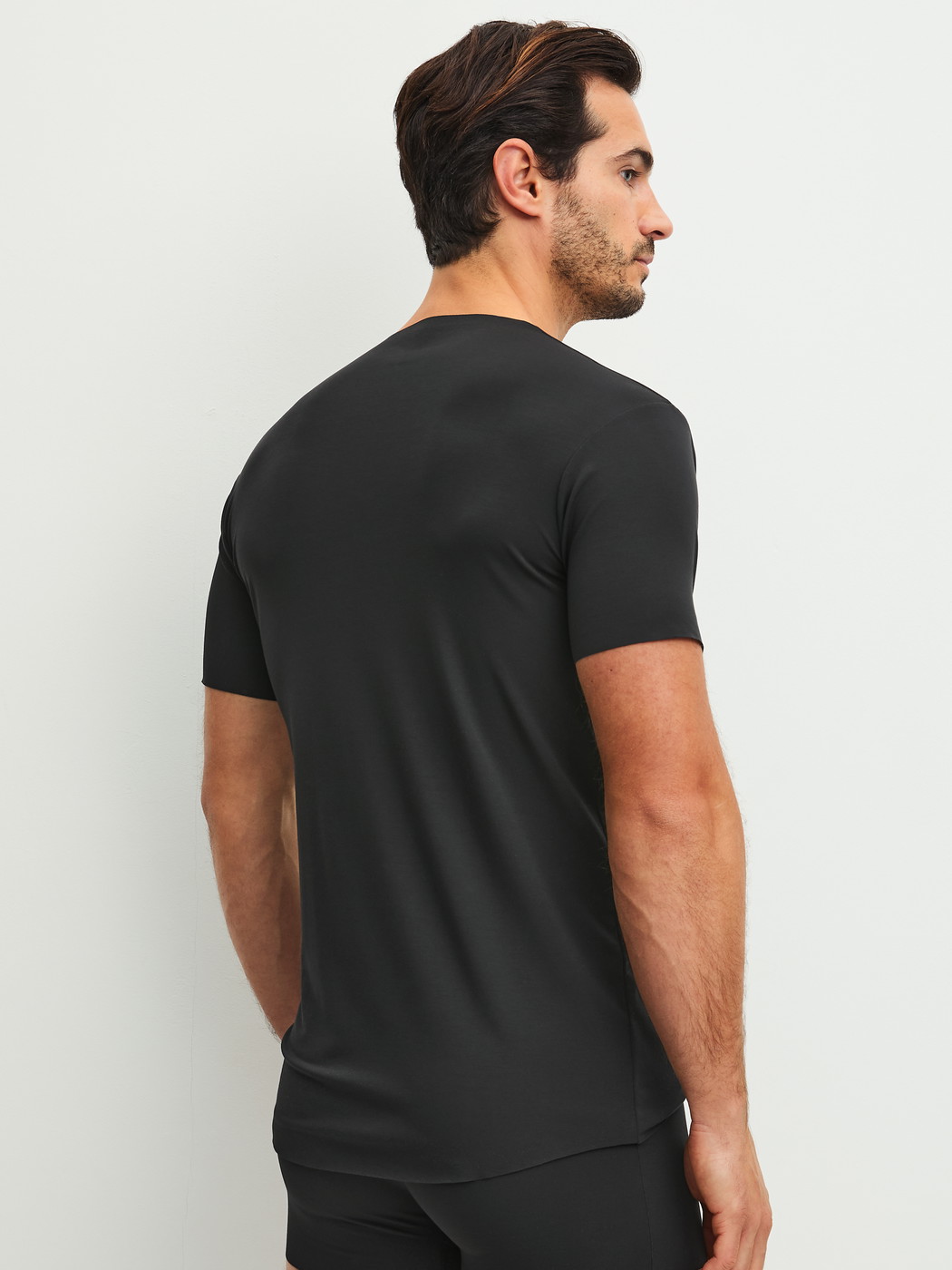 Men model is wearing V-shirt made of Modal in Black, Unicoloured from the Clean Line series by CALIDA, Back view