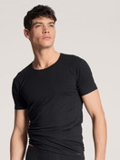 Herren-Model trägt T-Shirt, Rundhals aus Baumwolle in Schwarz, Einfarbig aus Serie Pure & Style von CALIDA, Vorderansicht