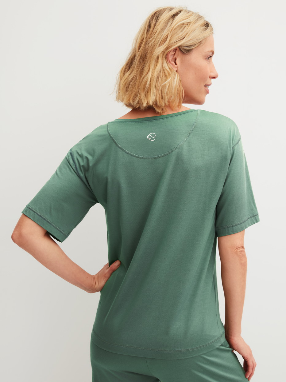 Damen-Model trägt Kurzarm-Shirt aus Modal in Grün, Einfarbig aus Serie DSW Balancing von CALIDA, Rückansicht