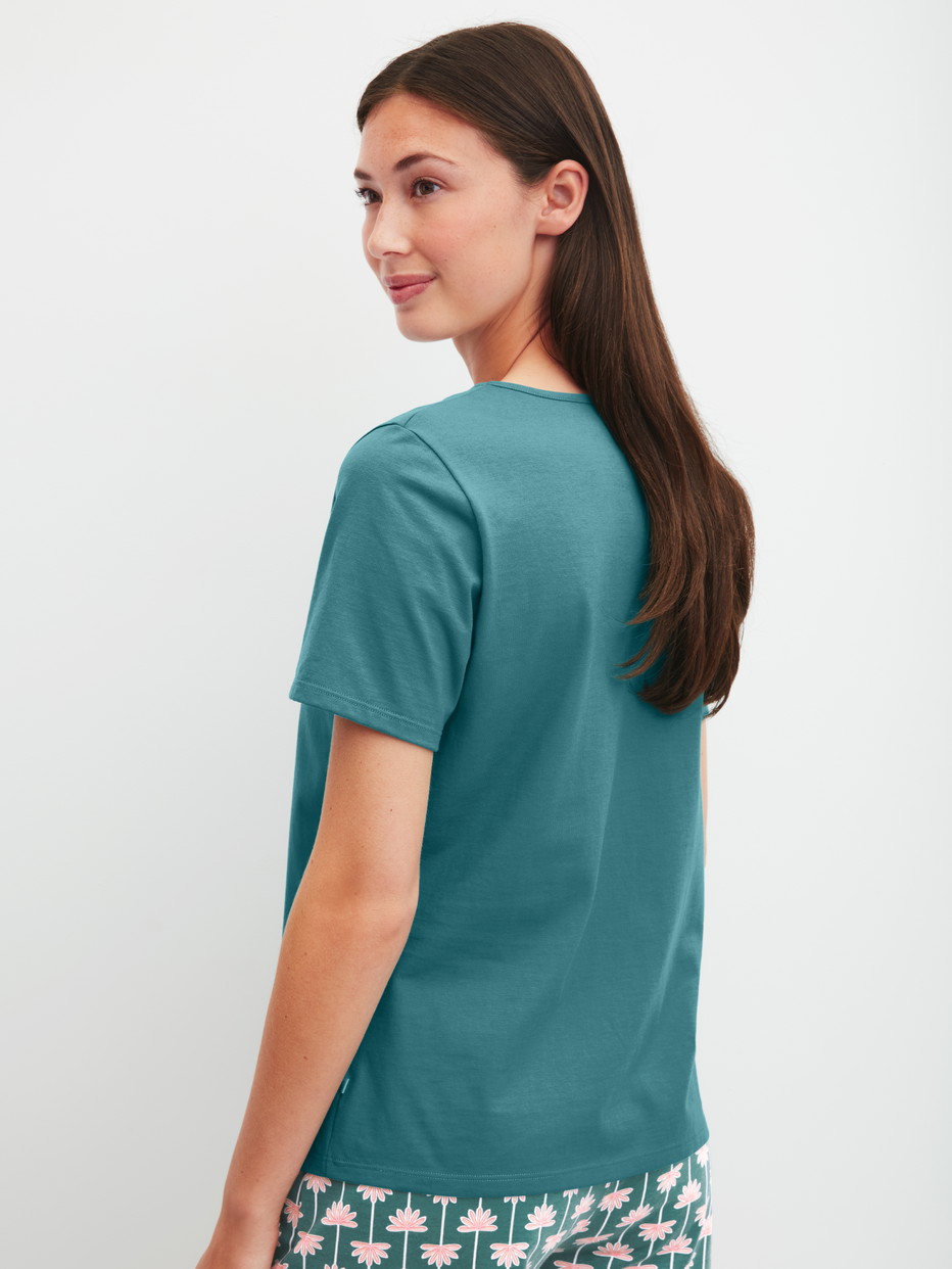 Damen-Model trägt Kurzarm-Shirt aus 100% Baumwolle in Türkis, Einfarbig aus Serie Favourites Beach von CALIDA, Rückansicht