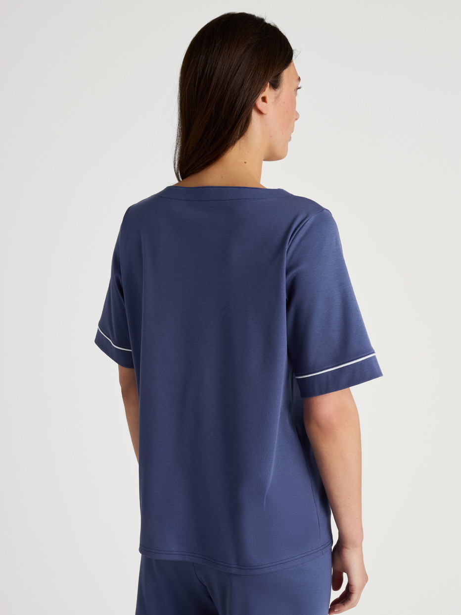 Damen-Model trägt Kurzarm-Shirt aus 100% Baumwolle in Blau, Einfarbig aus Serie Favourites Magic von CALIDA, Rückansicht