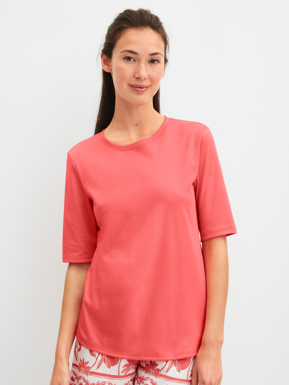 Damen-Model trägt Kurzarm-Shirt aus 100% Baumwolle in Orange, Einfarbig aus Serie Favourites Beach von CALIDA, Vorderansicht